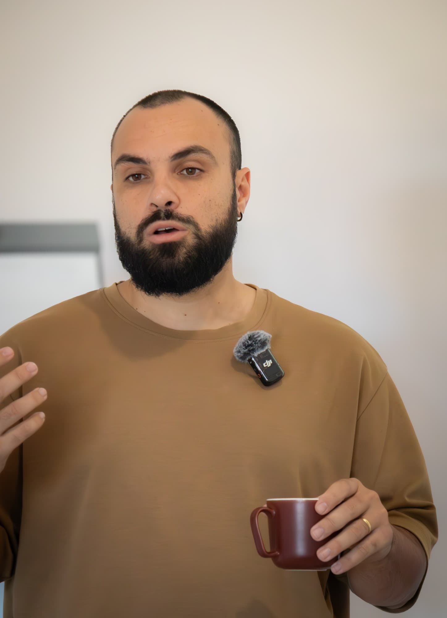Portrait de Bastien Bondu qui parle, une tasse à la main
